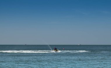 Meksika Körfezi 'nde jet ski süren bir adam. Sahildeki heyecan verici bir su sporu macerasının özünü somutlaştırıyor..
