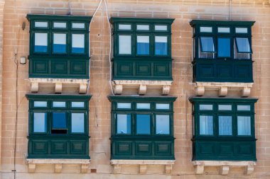 Valletta, Malta, 5 Mayıs 2023. Şehir merkezinde tipik pencereleri olan bir binanın ön cephesi