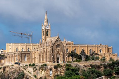 Gozo, Malta, 3 Mayıs 2023. Lourdes Leydisi 'nin manzarası, Mgarr Kilisesi bir tepenin üstünde