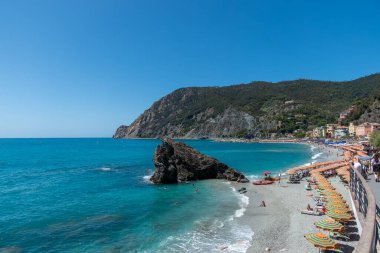 Monterosso, İtalya, 27 Temmuz 2023. Deniz manzarası, plaj, şemsiyeler ve turistler.