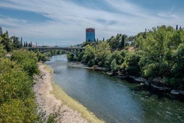 Podgorica, Karadağ, 5 Ağustos 2024 Ribnica Nehri ve Karadağ Bemax Binası Üzerine Bayrak