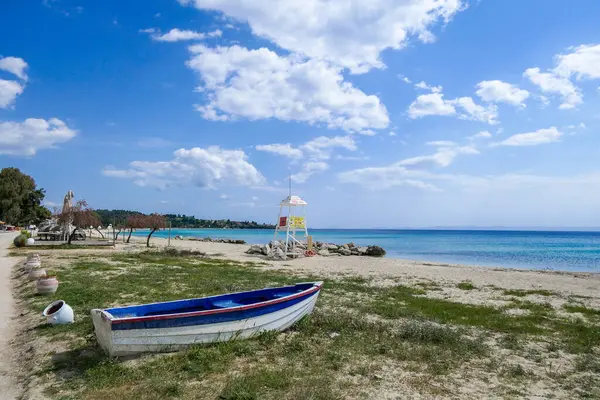 Nikiti, Yunanistan, 27 Nisan 2025. Cankurtaran kulesi ve renkli teknesi olan Nikiti Plajı