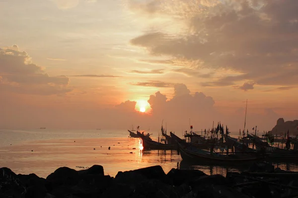 Deniz kıyısındaki küçük bir balıkçı teknesinin silueti..
