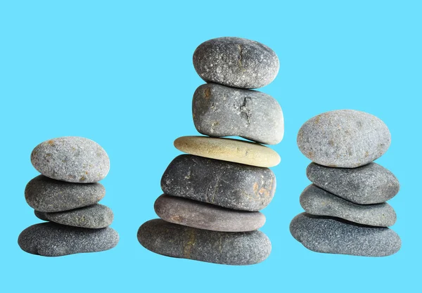 Balancing stone or rock isolated, natural pebble with clipping path, no shadow in blue background