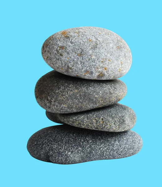 Balancing stone or rock isolated, natural pebble with clipping path, no shadow in blue background