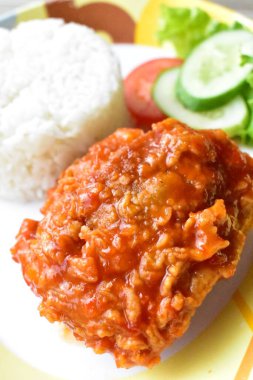 Kızarmış tavuk pilavı kesme yolu olan beyaz tabakta izole edilmiş, açık mavi arka planda gölge yok.