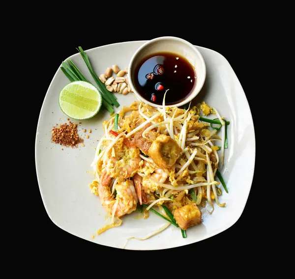 レモンとソース タイスタイル アジア料理 黒い背景のクリッピングパス付きの影で おいしいエビとホワイトディッシュで分離されたパッドタイ麺 — ストック写真
