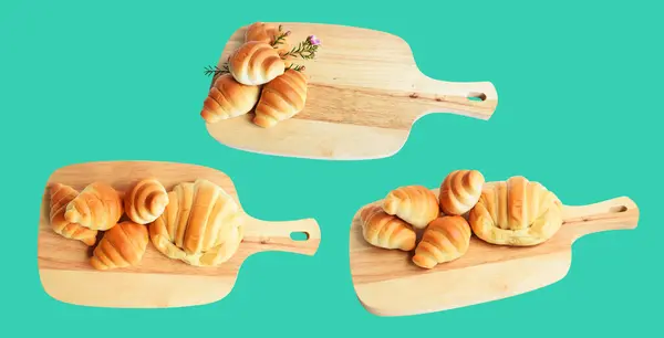 Cheese croissant isolated in wood cutting board with clipping path, no shadow in green background, homemade dessert