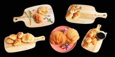 Tahta kesme tahtasına izole edilmiş peynirli kruvasan. Siyah arka planda gölge yok. Ev yapımı tatlı.