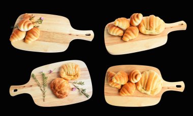 Tahta kesme tahtasına izole edilmiş peynirli kruvasan. Siyah arka planda gölge yok. Ev yapımı tatlı.