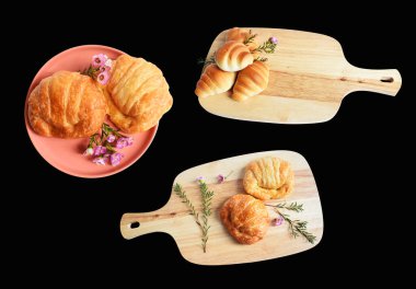 Tahta kesme tahtasına izole edilmiş peynirli kruvasan. Siyah arka planda gölge yok. Ev yapımı tatlı.