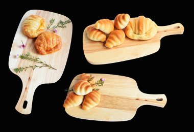 Tahta kesme tahtasına izole edilmiş peynirli kruvasan. Siyah arka planda gölge yok. Ev yapımı tatlı.