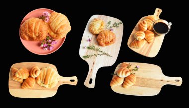 Tahta kesme tahtasına izole edilmiş peynirli kruvasan. Siyah arka planda gölge yok. Ev yapımı tatlı.