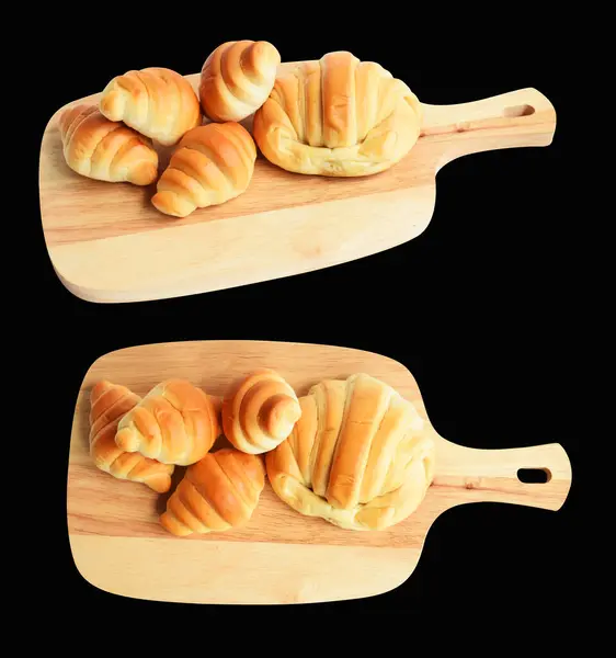 Cheese croissant isolated in wood cutting board with clipping path, no shadow in black background, homemade dessert