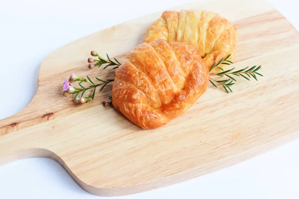 Cheese croissant isolated in wood cutting board in white background, homemade dessert
