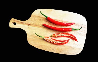 Kırmızı kırmızı biber ahşap üzerine izole edilmiş siyah arka planda kesme tahtası, kırpma yolu ile gölge yok, doğal baharat, pişirme malzemesi