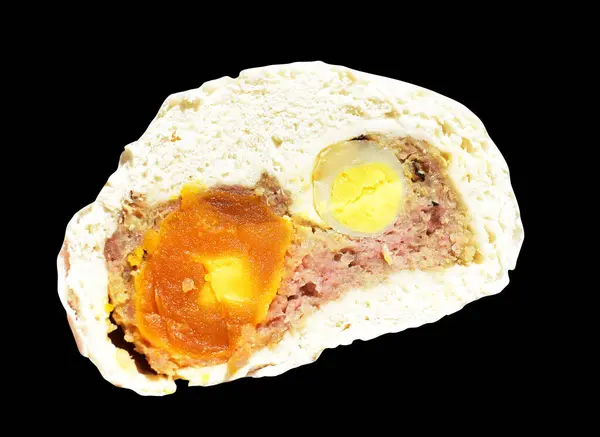 Baozi or Chinese steamed meat bun half isolated with pork meat and salted egg yolk and quail eggs in black background with clipping path and no shadow