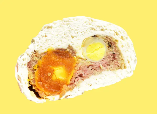 Baozi or Chinese steamed meat bun half isolated with pork meat and salted egg yolk and quail eggs in yellow background with clipping path and no shadow