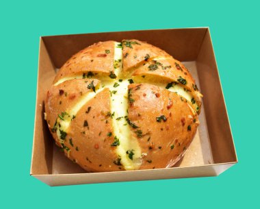 Kraft kutusundaki Kore krem peynirli sarımsaklı ekmek kırpma yolu ile izole edilmiş, yeşil arka planda gölge yok, hamur işi ekmeği