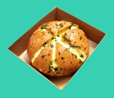 Kraft kutusundaki Kore krem peynirli sarımsaklı ekmek kırpma yolu ile izole edilmiş, yeşil arka planda gölge yok, hamur işi ekmeği