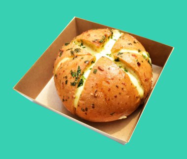 Kraft kutusundaki Kore krem peynirli sarımsaklı ekmek kırpma yolu ile izole edilmiş, yeşil arka planda gölge yok, hamur işi ekmeği