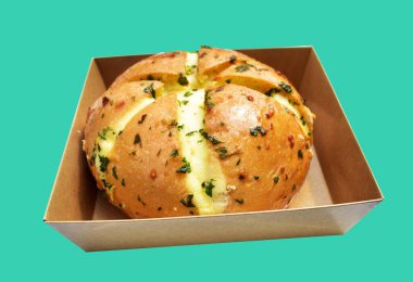 Kraft kutusundaki Kore krem peynirli sarımsaklı ekmek kırpma yolu ile izole edilmiş, yeşil arka planda gölge yok, hamur işi ekmeği