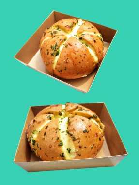 Kraft kutusundaki Kore krem peynirli sarımsaklı ekmek kırpma yolu ile izole edilmiş, yeşil arka planda gölge yok, hamur işi ekmeği