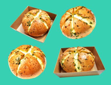 Kraft kutusundaki Kore krem peynirli sarımsaklı ekmek kırpma yolu ile izole edilmiş, yeşil arka planda gölge yok, hamur işi ekmeği