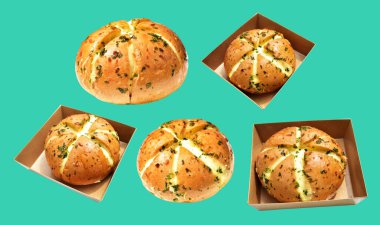 Kraft kutusundaki Kore krem peynirli sarımsaklı ekmek kırpma yolu ile izole edilmiş, yeşil arka planda gölge yok, hamur işi ekmeği