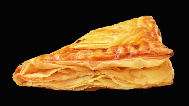 Puf böreği üçgeni izole edilmiş peynirli gevrek hamur işi kesme yolu olan domuz eti dolu, siyah arka planda gölge yok.