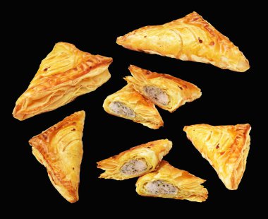 Puf böreği üçgeni izole edilmiş peynirli gevrek hamur işi kesme yolu olan domuz eti dolu, siyah arka planda gölge yok.