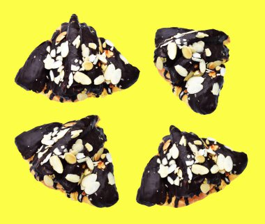 Kruvasan koyu çikolata soslu ve sarı arka planda izole edilmiş badem dilimli, gölgesiz, ev yapımı tatlı fırını pastası.