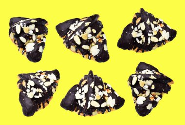 Kruvasan koyu çikolata soslu ve sarı arka planda izole edilmiş badem dilimli, gölgesiz, ev yapımı tatlı fırını pastası.