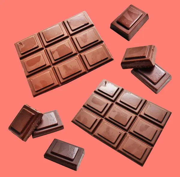 Milk chocolate pieces isolated with clipping path, no shadow in pink background, cooking ingredient, homemade sweet dessert