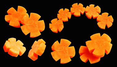 Çiçek şeklinde havuç dilimleri kırpma yolu ile izole edilmiş, siyah arka planda gölge yok, taze çiğ sebze, pişirme malzemesi