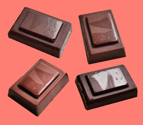 Milk chocolate pieces isolated with clipping path, no shadow in pink background, cooking ingredient, homemade sweet dessert