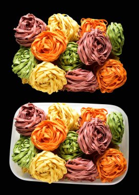 Renkli İtalyan tagliatelle veya Fettuccine makarnası klasik istif, yuva yumurtası İtalyan makarnası kırpma yolu izole, siyah arka planda gölge yok, yemek malzemesi yok