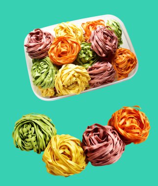 Renkli İtalyan tagliatelle ya da Fettuccine makarnası klasik istif. Yuva yumurtası, kırpma yolu ile izole edilmiş İtalyan makarnası. Yeşil arka planda gölge yok.