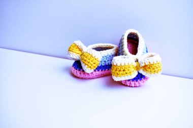 Yeni doğmuş bebek ayakkabıları ya da beyaz arka planda izole edilmiş çocuklar için el yapımı ayakkabılar, hamilelik anneliği kavramı, ilk doğum günü partisi afişi.