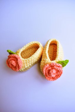 Yeni doğmuş bebek ayakkabıları ya da beyaz arka planda izole edilmiş çocuklar için el yapımı ayakkabılar, hamilelik anneliği kavramı, ilk doğum günü partisi afişi.