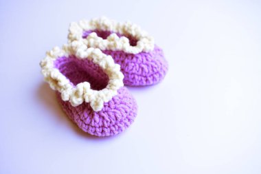 Yeni doğmuş bebek ayakkabıları ya da beyaz arka planda izole edilmiş çocuklar için el yapımı ayakkabılar, hamilelik anneliği kavramı, ilk doğum günü partisi afişi.