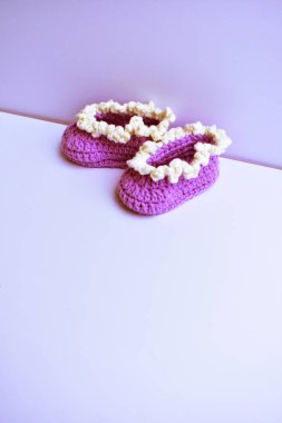 Yeni doğmuş bebek ayakkabıları ya da beyaz arka planda izole edilmiş çocuklar için el yapımı ayakkabılar, hamilelik anneliği kavramı, ilk doğum günü partisi afişi.