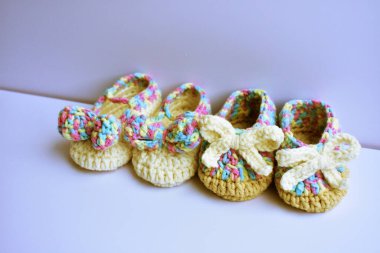 Yeni doğmuş bebek ayakkabıları ya da beyaz arka planda izole edilmiş çocuklar için el yapımı ayakkabılar, hamilelik anneliği kavramı, ilk doğum günü partisi afişi.