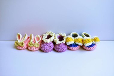 Yeni doğmuş bebek ayakkabıları ya da beyaz arka planda izole edilmiş çocuklar için el yapımı ayakkabılar, hamilelik anneliği kavramı, ilk doğum günü partisi afişi.