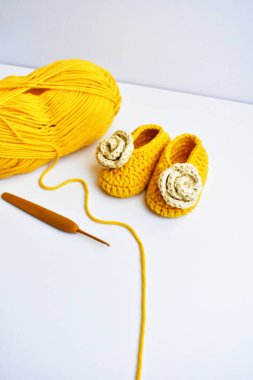 Yeni doğmuş bebek ayakkabıları ya da beyaz arka planda izole edilmiş çocuklar için el yapımı ayakkabılar, hamilelik anneliği kavramı, ilk doğum günü partisi afişi.