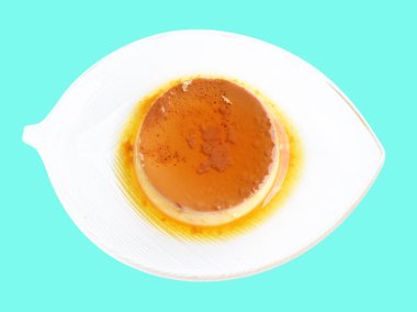 Pişmiş karamel flan şifonlu kek ya da muhallebi keki izole edilmiş, kırpma yolu olmayan gölge yok, naneli arka planda gölge yok, yumurta ve süte dayalı nefis bir tatlı.