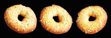 Kesme yolu ile izole edilmiş susam tohumlarıyla kaplı tereyağlı kurabiyeler. Siyah arkaplanda gölge yok.