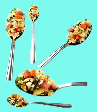 Kırpılmış bir kaşık kızarmış pirinç, yeşil arka planda gölge yok. Çin pilavı, karışık sebze, yumurta ve sosis (Yangzhou tarzı).)