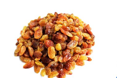 Beyaz arka planda izole edilmiş sarı ve kahverengi kuru üzüm yığınları. Güneşli ve parlak.