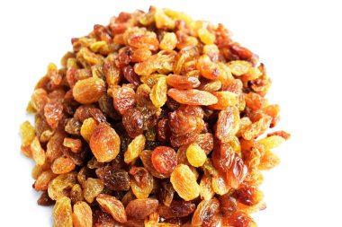 Beyaz arka planda izole edilmiş sarı ve kahverengi kuru üzüm yığınları. Güneşli ve parlak.